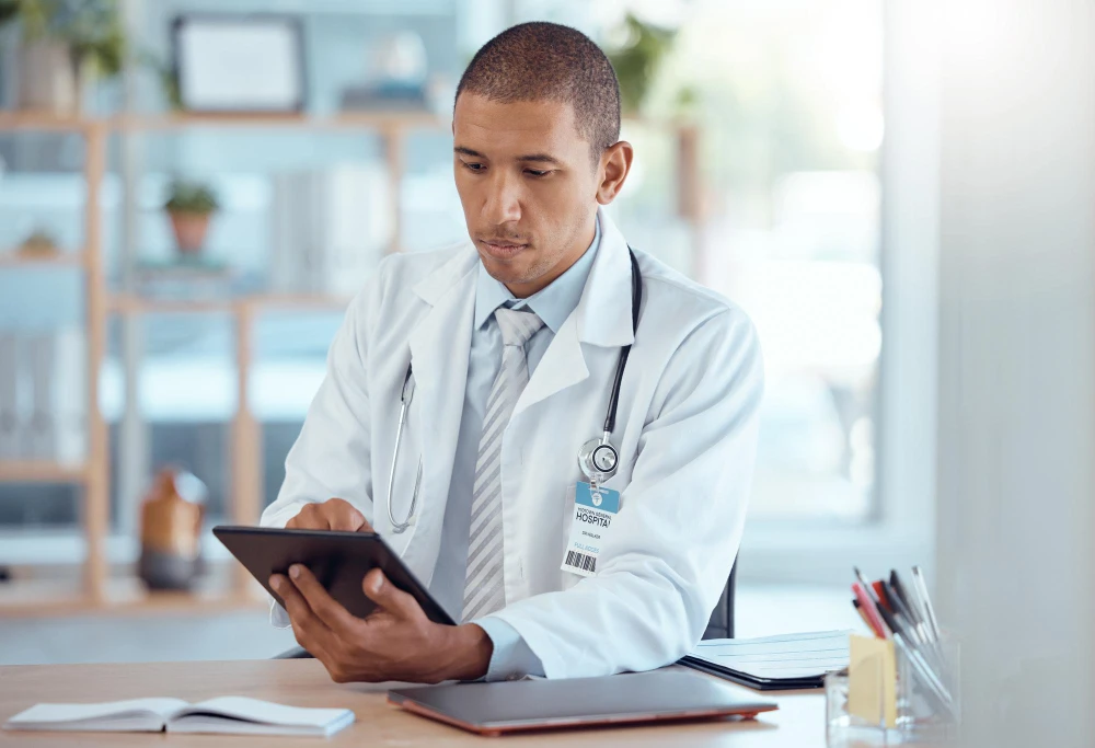 Foto de médico com tablet. Entenda o potencial da auditoria em saúde suplementar