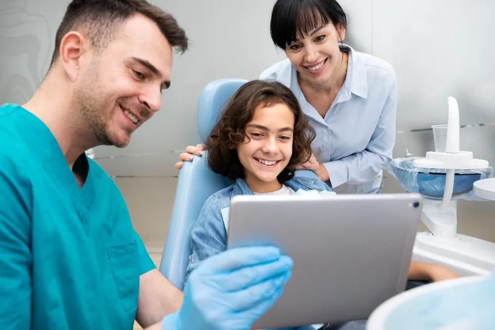 Foto de pacientes e dentista olhando tablet. Descubra como melhorar a gestão de planos odontológicos