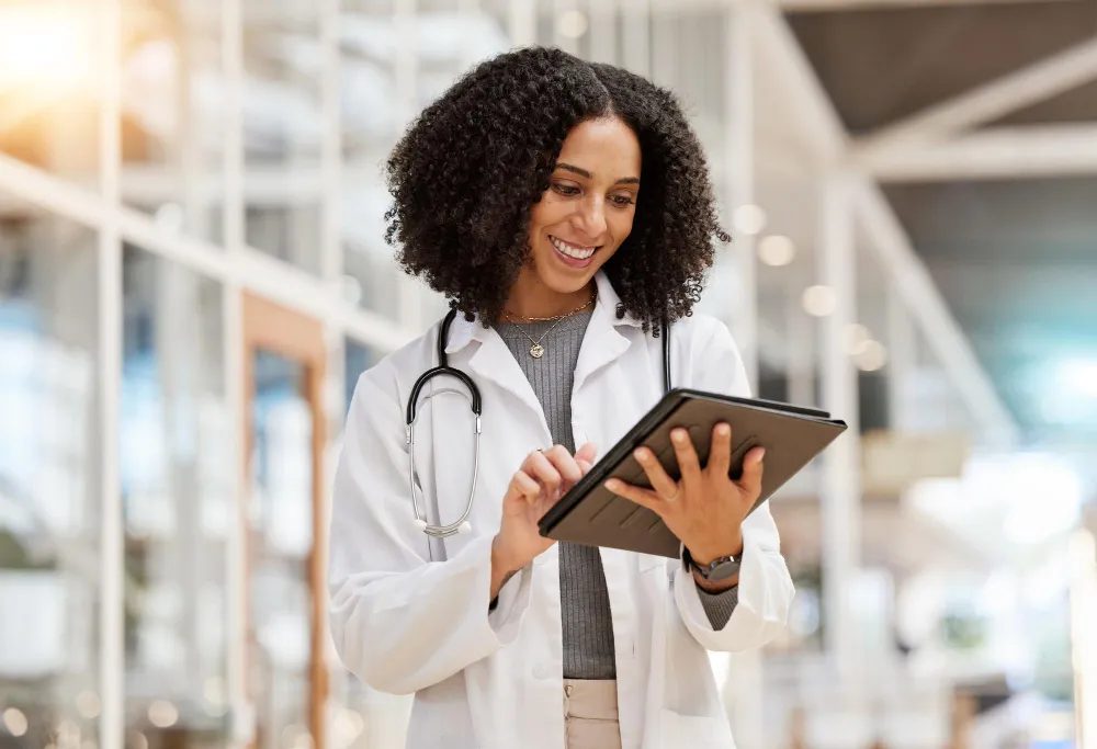 O impacto da automação de processos na rotina das operadoras de saúde Foto de médica utilizando tablet. Automação de processos melhora a gestão na saúde suplementar