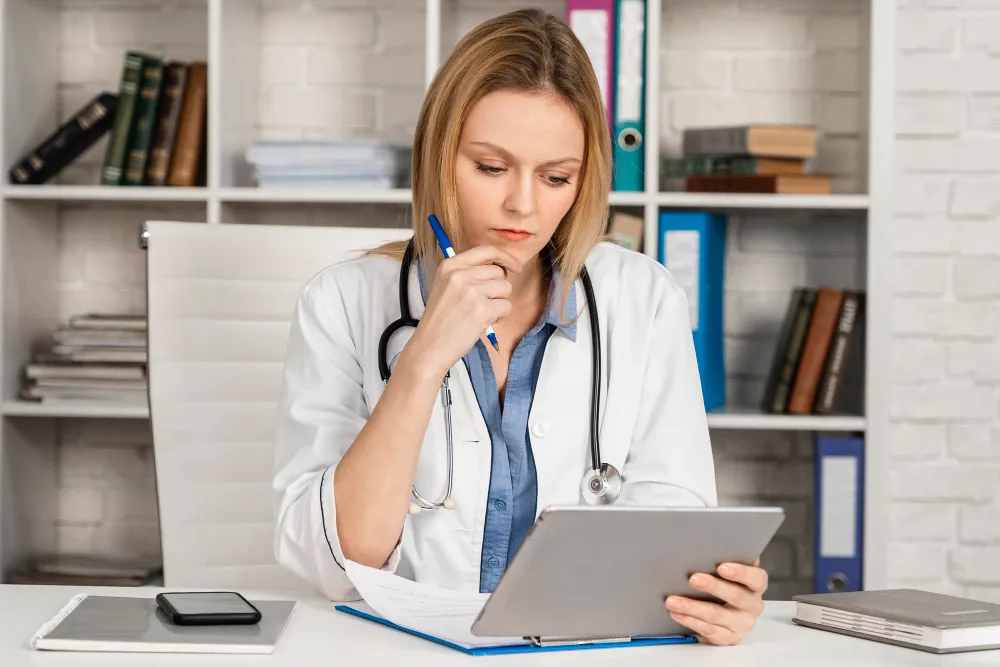 Por que a gestão de risco deve ser prioridade na saúde suplementar? Foto de profissional de saúde olhando para tablet. Entenda a gestão de riscos em operadoras.